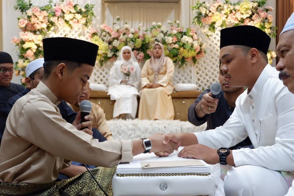 Muhammad Afif Hakimi Mohd Haled (kiri), 15 tahun, menjadi wali dalam upacara pernikahan antara kakak kandungnya, Cik Nur Farisha Irwanie Mohd Haled dan Encik Mikhail Adam Yusri pada 3 Februari di Masjid Ukay Perdana.