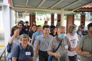 Menteri Pembangunan Negara, Encik Desmond Lee (barisan dua, tengah) semasa Acara Berjalan Kaki bagi Peningkatan Masyarakat (CIP) bersama penduduk warga emas Chong Boon pada 25 Ogos. 