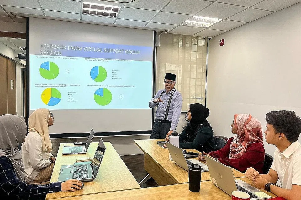 BINCANG HALA TUJU: Encik Md Yusof Ismail (berdiri) memberi taklimat kepada pasukannya. Persatuan Ain kini mempunyai 22 pekerja, majoriti merupakan kaunselor dan ahli psikologi.