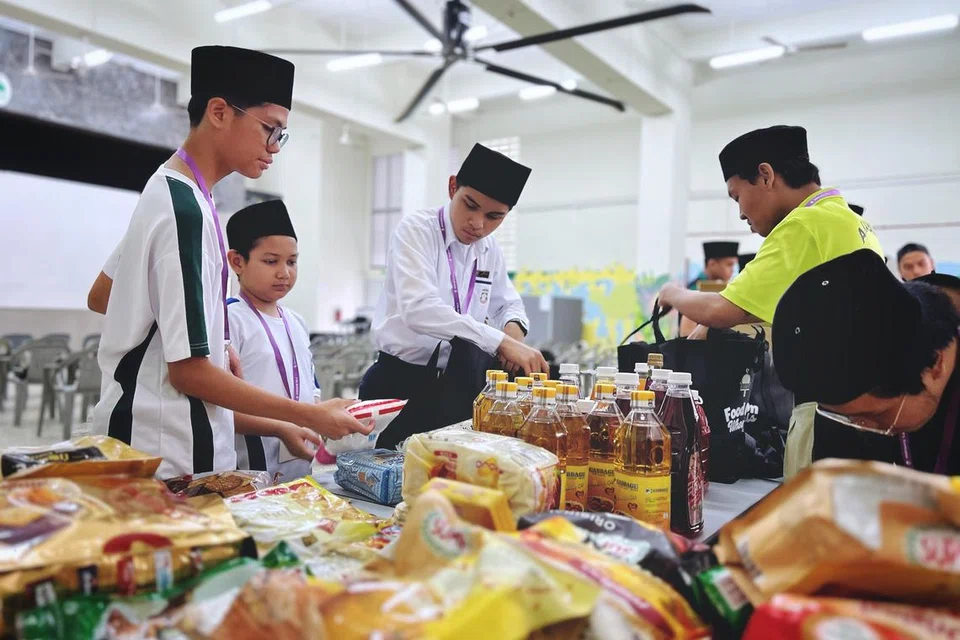 Pelajar Madrasah Aljunied Al-Islamiah, Muhammad Salim (tiga dari kiri), kelihatan membungkus habuan Ramadan di Rumah Peralihan Pertapis pada pagi 2 Mac.