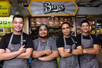 PENJAJA 'BURGS': Pasukan cef muda yang terdiri daripada (dari kiri) Encik Lee Syafiq Muhammad Ridzuan Lee, Encik Hidayat Sutrisno, Encik Muhd Shafie Abdul Rahim, dan Encik Muhammad Shah Indra Jasni, mengusahakan gerai penjaja Burgs by Project Warung di Pusat Makanan Golden Mile. - Foto BH oleh DIOS VINCOY JR 