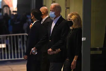 LANGKAH SEIRINGAN: Calon Parti Demokrat, Encik Joe Biden, yang mendahului kiraan undi di Georgia dan Arizona, dilihat berjalan berpimpin tangan dengan isterinya, Cik Jill Biden, selepas selesai berucap di Queen, Wilmington, Delaware, lewat kelmarin. - Foto AFP