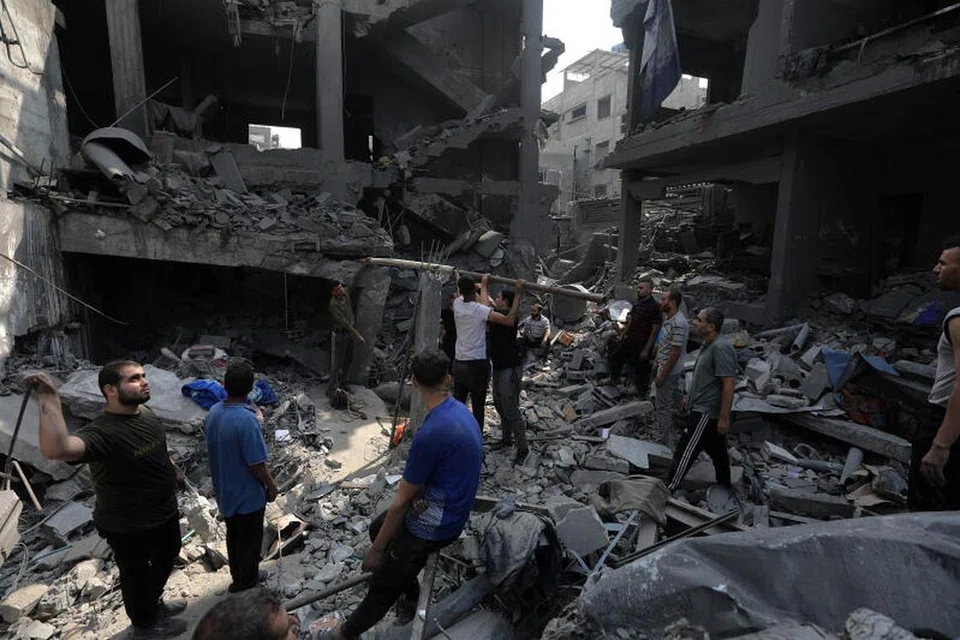 KESAN SERANGAN: Beberapa warga Palestin mencari anggota keluarga yang terbenam di bawah sebuah bangunan yang runtuh menyusuli serangan udara Israel ke kawasan utara Gaza pada Sabtu. 
