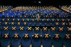 LENGANG DAN SEPI: Seorang pekerja dilihat memeriksa kerusi-kerusi dalam panggung wayang CGV di Jakarta pada 21 Oktober lalu yang dipangkah dan tidak boleh diduduki sebagai langkah membendung penularan koronavirus sehingga menjejas industri perfileman Indonesia. - Foto REUTERS 