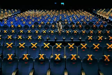 LENGANG DAN SEPI: Seorang pekerja dilihat memeriksa kerusi-kerusi dalam panggung wayang CGV di Jakarta pada 21 Oktober lalu yang dipangkah dan tidak boleh diduduki sebagai langkah membendung penularan koronavirus sehingga menjejas industri perfileman Indonesia. - Foto REUTERS 