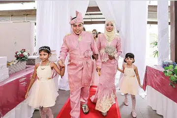 RIUH-RENDAH KOLONG BLOK: Cik Sharmila dan suami Encik Yuswira seronok menikmati suasana kekecohan di kolong blok, meskipun tidak menjemput tetamu yang ramai. - Foto GLAMZ GALLERY