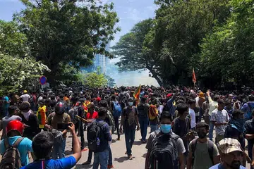 CUBA MASUKI RUMAH PERDANA MENTERI: Polis melepaskan gas pemedih mata ke atas rakyat Sri Lanka yang mengadakan bantahan besar-besaran dan cuba memasuki kediaman rasmi perdana menteri negara itu. - Foto AFP