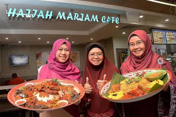 MENU BERTAMBAH: Hajah Mariam (tengah) bersama dua anak perempuannya, Cik Azidah (kiri) dan Cik Adhana, bukan sahaja memperkenal menu baru nasi tomat, malah turut meluaskan ruang kedai mereka. - Foto JOHARI RAHMAT