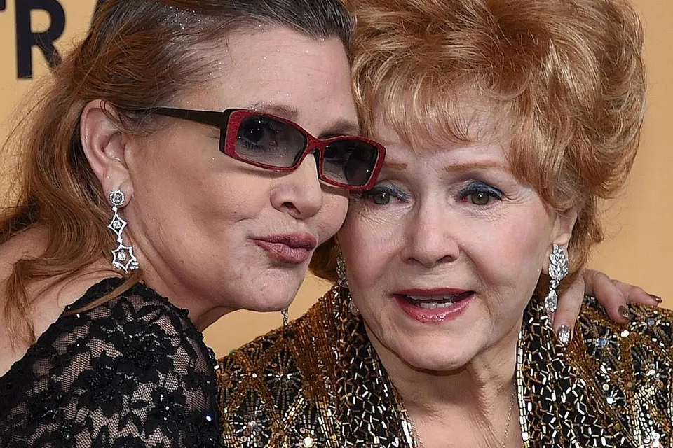 PERGI SELAMANYA: Legenda Debbie Reynolds (kanan) meninggal dunia selang sehari selepas anaknya, Carrie Fisher (kiri), meninggal. - Foto AFP
