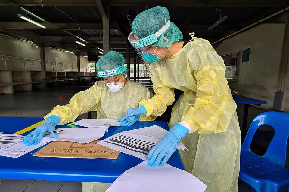 PEJUANG COVID-19: Atiq (kiri, gambar kanan) lengkap dengan pakaian peralatan perlindungan diri (PPE) semasa bertugas di pusat perubatan di asrama pekerja asing Woodlands Lodge. - Foto ALEX CHUA