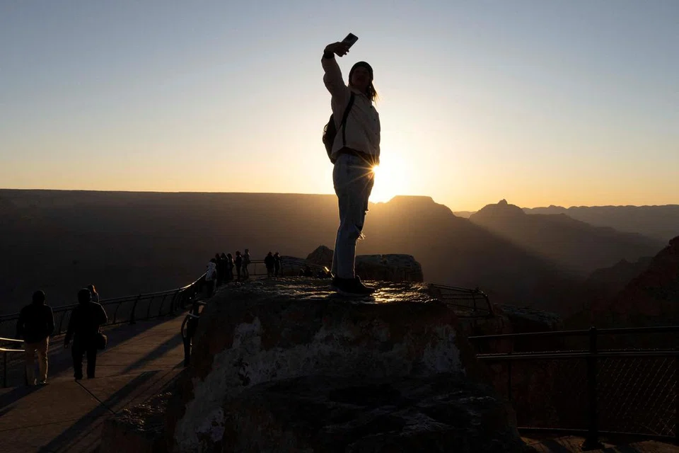 Pelancong asing berkongsi matahari terbit di pinggir selatan Taman Negara Grand Canyon melalui panggilan video berhampiran Tusayan, Arizona (gambar hiasan).