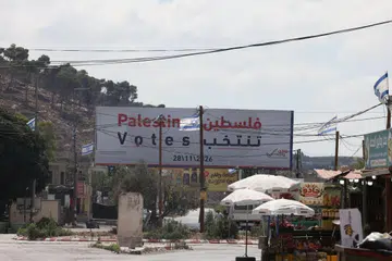 Papan iklan pilihan raya Parlimen Palestin dipasang di tepi jalan berhampiran bandar Jenin, Tebing Barat, pada 25 September 2026, dengan bendera Israel kelihatan berhampiran. Pilihan raya yang dijadualkan pada 28 November itu kini dijangka ditangguhkan sehingga 2027 berikutan pertikaian antara kumpulan politik Palestin serta kesukaran mengadakan pengundian di Jaluran Gaza dan Baitulmaqdis Timur.
