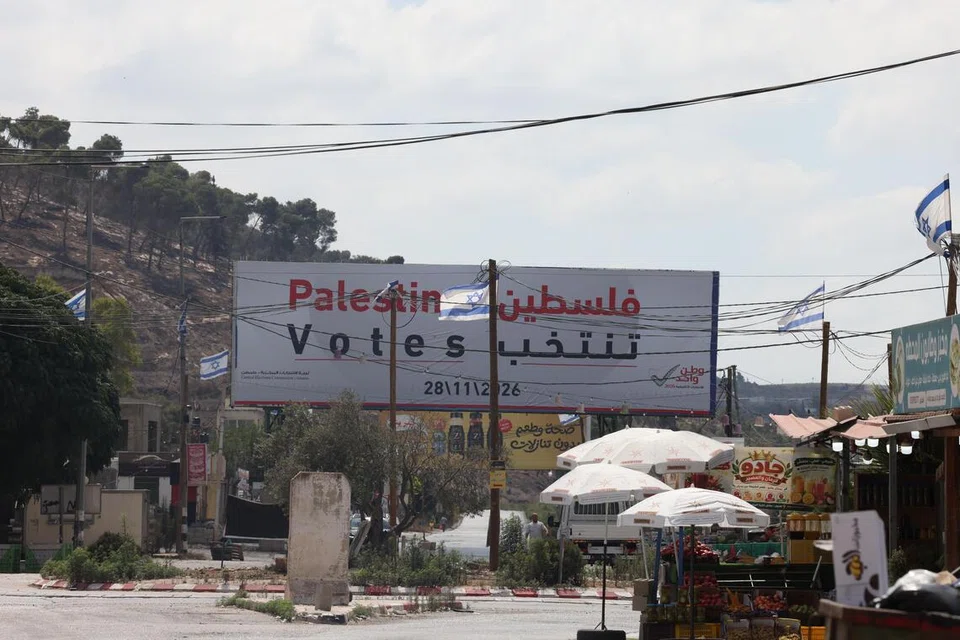 Papan iklan pilihan raya Parlimen Palestin dipasang di tepi jalan berhampiran bandar Jenin, Tebing Barat, pada 25 September 2026, dengan bendera Israel kelihatan berhampiran. Pilihan raya yang dijadualkan pada 28 November itu kini dijangka ditangguhkan sehingga 2027 berikutan pertikaian antara kumpulan politik Palestin serta kesukaran mengadakan pengundian di Jaluran Gaza dan Baitulmaqdis Timur.