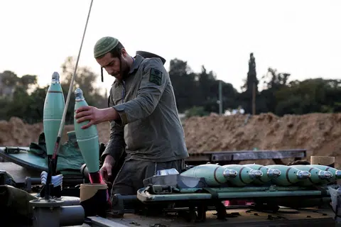 PERLU LINDUNGI ORANG AWAM: Seorang askar Israel sedang menyiapkan peluru mortar untuk diluncurkan dekat sempadan Gaza pada 22 Januari.