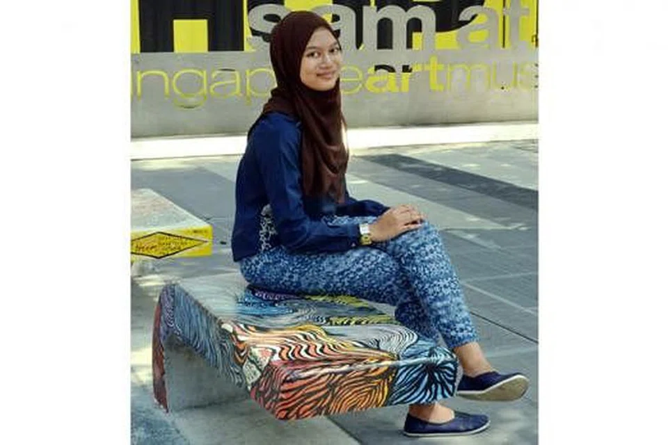 LUKISAN SPONTAN: Cik Nur Syuhada Ahmad Soribah gembira kesungguhannya memalit lorekan dan lengkungan cat yang tampak 'seksi' pada bangku ini dihargai. 