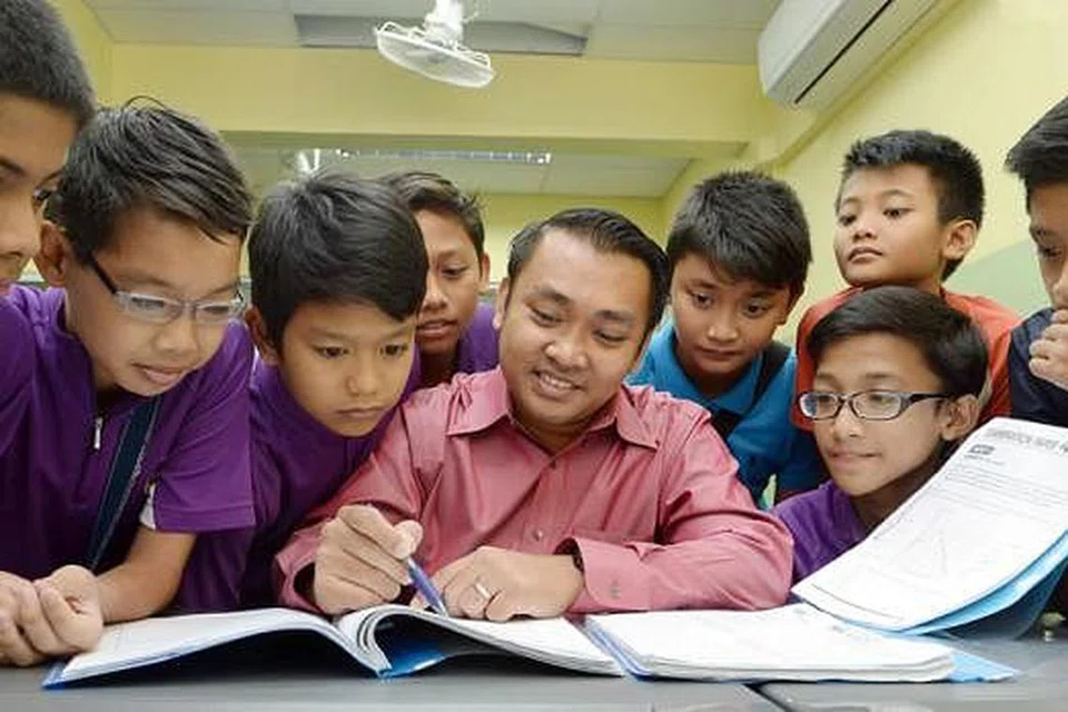 GALAK PELAJAR FIKIR DI LUAR KOTAK: Sekumpulan pelajar darjah enam khusyuk mendengar penjelasan Encik Ahmad Salik (tengah) mengenai satu masalah matematik di kelas tuisyennya. - Foto-foto TAUFIK A. KADER