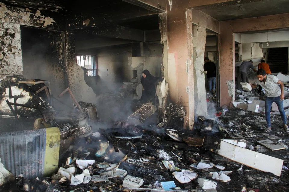 Penduduk Palestin memeriksa kerosakan di sebuah sekolah yang melindungi mereka yang kehilangan tempat tinggal di kem pelarian Shati, Bandar Gaza, pada 7 November, susulan serangan udara tentera Israel.