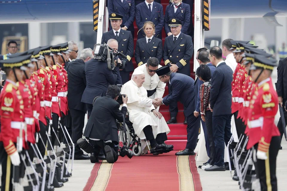 Menteri Hal Ehwal Agama Indonesia, Encik Yaqut Cholil Qoumas (bersongkok), bersalaman dengan Paus Francis (berkerusi roda) semasa menyambut ketibaan pemimpin agama itu di Lapangan Terbang Antarabangsa Soekarno-Hatta di Jakarta, Indonesia, pada 3 September. Paus Francis berada di Indonesia dalam rangka lawatan empat negara di Asia-Pasifik termasuk Singapura.