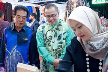 GANDING BAHU UNTUK FAEDAH MASYARAKAT: (dari kiri) Pengarah Urusan MegaXpress, Encik Hamzah Haji Abdullah, bersama-sama Pengerusi Eksekutif Masjid Muhajirin, Haji Kassim Kamis dan AP GRC Jurong, Cik Rahayu Mahzam, melihat-lihat barangan yang dipamerkan dan dijual di Pameran Perkahwinan Mega dan Gaya Hidup 2019 di dewan Ekspo Singapura 6A semalam. - Foto BH oleh NUR DIYANA TAHA