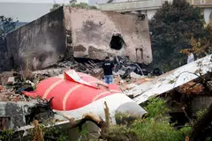 Seorang anggota bomba berdiri di sebelah pesawat Air India yang terhempas, di Ahmedabad, India, pada 13 Jun.
