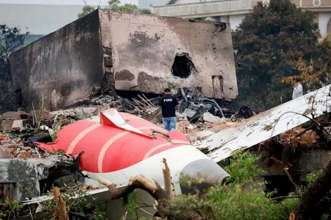 Seorang anggota bomba berdiri di sebelah pesawat Air India yang terhempas, di Ahmedabad, India, pada 13 Jun.