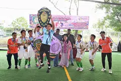 Cik Mariam (tengah, berkalung bunga anggerik) bersama Woodlands Warrior FC,  juara pertandingan VJS Urban Futsal Copa bawah 18 tahun.