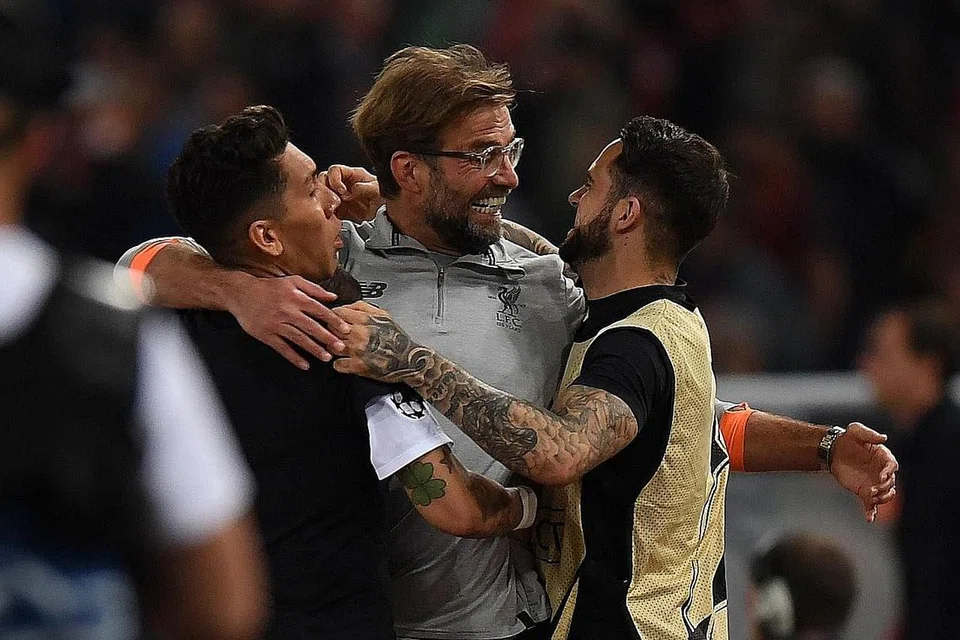 PELUKAN KEJAYAAN: Pengurus Liverpool, Juergen Klopp (tengah) meraikan kejayaan pasukan ke final Liga Juara-Juara dengan bintang pasukan, Roberto Firmino (kiri) dan Danny Ings. - Foto AFP 