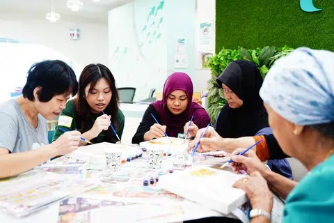 Sukarelawan daripada BeKhayr dan warga emas sambil melakukan aktiviti melukis motif Batik semasa acara ‘BeRiang BerKhayr’ pada 23 April di Pusat Penuaan Aktif  NTUC Health (Penjagaan) di Bedok North.
