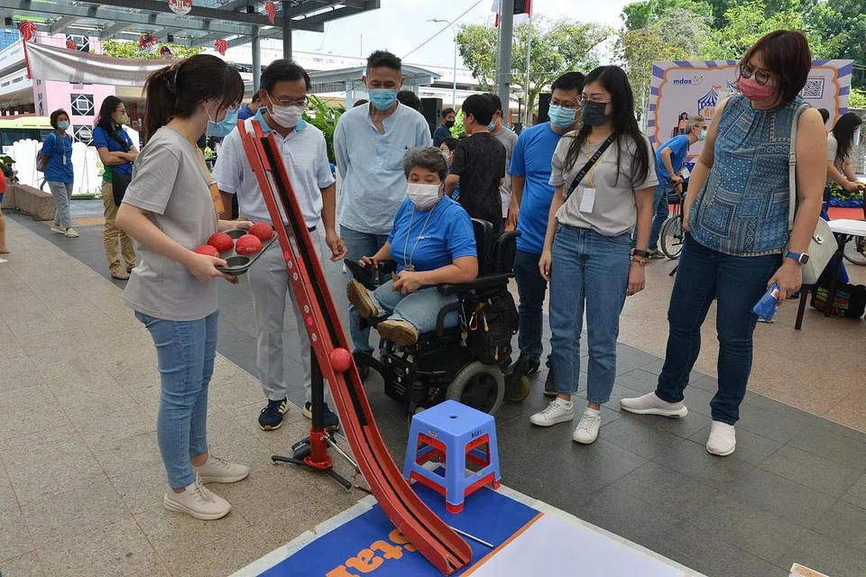 PUPUK KESEDARAN: Anggota Parlimen (AP) Encik Chong Kee Hiong (GRC Bishan-Toa Payoh) (dua dari kiri) dengan beberapa wakil Persatuan Distrofi Otot Singapura (MDAS) mencuba sukan Boccia di sebuah pesta pupuk kesedaran tentang penyakit Distrofi Otot di Kelab Masyarakat Bishan semalam. - Foto MDAS