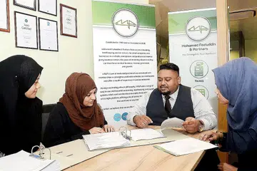 MANFAAT DIGITAL: Encik Mohamed Fazluddin Mohd Hanipah, yang bersama kakitangannya, berkata bagi perniagaan mikro seperti penjual kuih, tukang jahit dan tukang urut, terdapat sistem tempahan yang membolehkan pelanggan melihat jadual dan memasukkan masa pilihan mereka tanpa perlu menghubungi peniaga. - Foto JOHARI RAHMAT