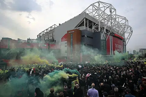 BANTAHAN LAGI: Para penyokong United sekali lagi mengadakan bantahan di luar Old Trafford sebelum perlawanan menentang Liverpool semalam. Perlawanan antara kedua-dua kelab itu telah ditangguhkan setelah peminat membuat bantahan yang turut menyaksikan mereka memasuki padang. - Foto AFP