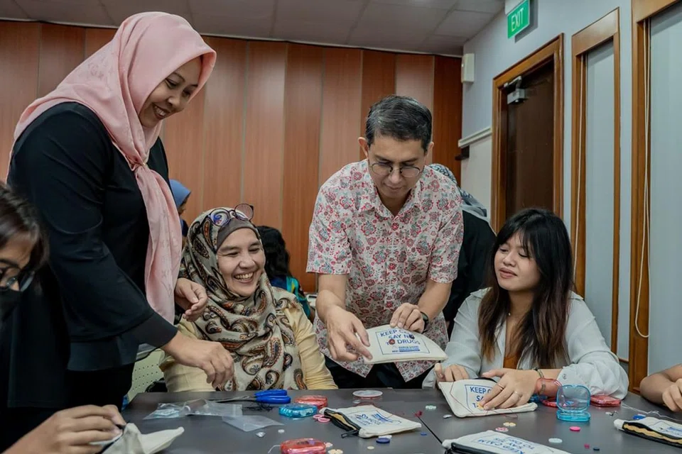 PROJEK 'SEW' BUTANG: Cik Zulaikha (paling kanan), salah seorang penerima Dana Pendidikan Harun Ghani (HGEF), belajar menjahit butang dengan bimbingan relawan HGEF, Cik Saleha Abdul Rahman (dua dari kiri) di acara HGEF semalam. Bersama mereka ialah setiausaha kehormat HGEF, Cik Haslinda (kiri) dan Dr Faishal. - Foto BM oleh NUR DIYANA TAHA