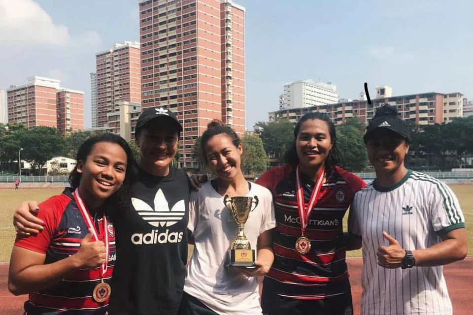 Wartawan Berita Harian Zulaiqah Abdul Rahim (dua dari kanan) bergambar bersama (dari kiri) rakan sepasukannya Nadzirah Ahmad, pemain New Zealand Portia Woodman-Wickliffe, rakan sepasukannya Faith Lim, dan bekas pemain New Zealand Renee Woodman-Wickliffe, selepas kemenangan pasukannya dalam final Liga Kebangsaan 15 Sepasukan Wanita Kesatuan Ragbi Singapura pada 2019.
