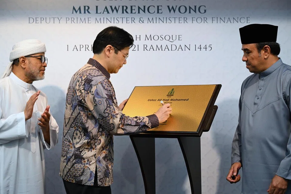 Timbalan Perdana Menteri, Encik Lawrence Wong, menandatangani plak merasmikan penamaan Auditorium ‘Ustaz Ali Haji Mohamed’, sambil diiringi Pengerusi Bersama Kumpulan Pemulihan Keagamaan (RRG), Ustaz Mohamad Hasbi Hassan (kiri) dan Ustaz Dr Mohamed Ali (kanan), yang juga Pengerusi Lembaga Pentadbir Masjid Khadijah dalam acara yang diadakan di Masjid Khadijah pada 1 April.