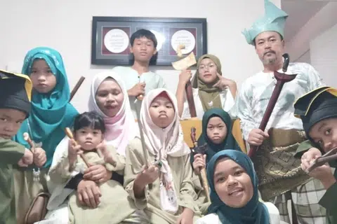 Keluarga (kanan, bertanjak) Encik Zuraimi dengan telatah masing-masing semasa mahu bergambar ketika Hari Raya.