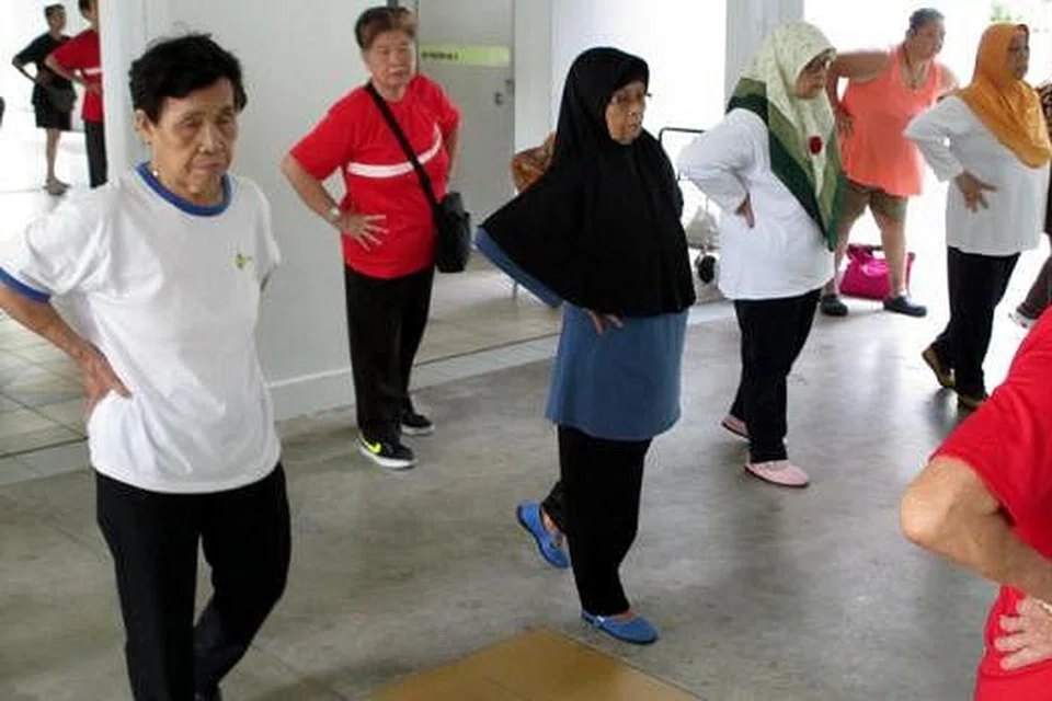 GIAT BERSENAM: Setiap hari Isnin, Cik Tomirah Seban (bertudung hitam) akan melakukan senaman qigong sebelah pagi di kolong bloknya bersama penduduk warga emas lain pelbagai bangsa. - Foto SUNLOVE MARSILING