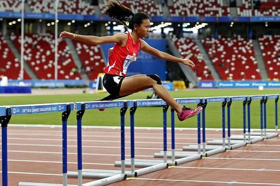 RANGKUL PINGAT BERSEJARAH: Walaupun meraih pingat gangsa, Nur Izlyn Zaini menjadi wanita Singapura pertama yang memenangi pingat dalam acara 100 meter lari lompat pagar wanita. - Foto SINGSOC