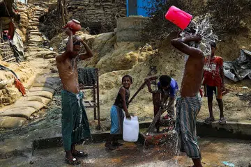 BERSIHKAN DIRI: Sebilangan orang Rohingya di kem pelarian Cox's Bazar, Bangladesh, sedang membersihkan diri menggunakan air daripada perigi. Mereka masih berharap dapat pulang ke tanah air mereka di wilayah Rakhine, Myanmar. - Foto REUTERS