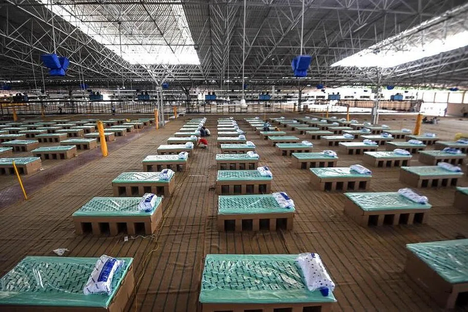 Katil kadbod dipasang di dalam dewan kampus sebuah pertubuhan kerohanian yang diubah menjadi pusat jagaan Covid-19 dengan 10,000 katil di New Delhi.