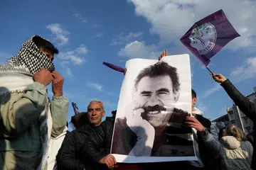 Penunjuk perasaan memegang gambar pemimpin Parti Pekerja Kurdi, Abdullah Ocalan, yang kini berada dalam penjara semasa bantahan di Diyarbakir, Turkey, pada 27 Februari.
