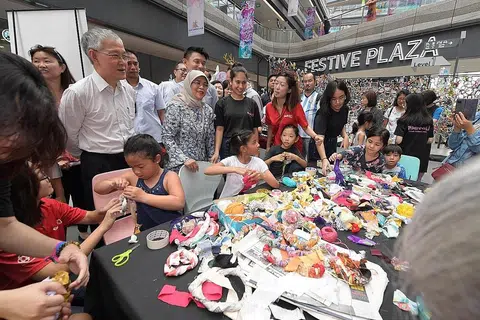 KESEJAHTERAAN MENTAL MENERUSI SENI: Presiden Halimah Yacob (dua dari kiri) bersama Dr Francis Yeoh (kiri) dan Anggota Parlimen GRC Tampines, Encik Baey Yam Keng (belakang Puan Halimah), sedang melihat beberapa aktiviti seni yang dijalankan di Our Tampines Hub sempena pelancaran Creative Mindset Hub. - Foto BH oleh ALPHONSUS CHERN