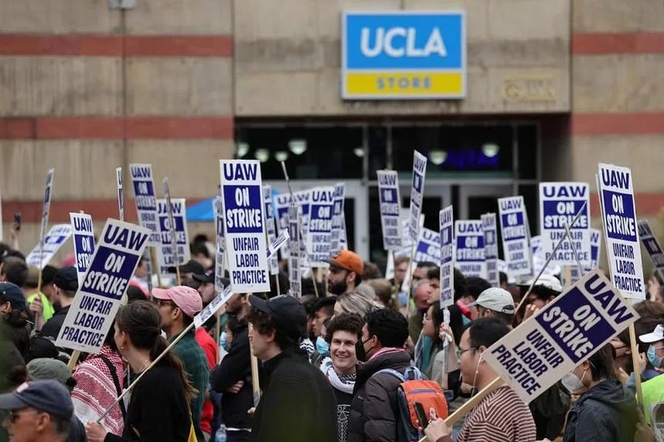 Kakitangan akademik yang menganggotai kesatuan sekerja memegang sepanduk ketika melancarkan mogok di Universiti California Los Angeles pada 28 Mei. 