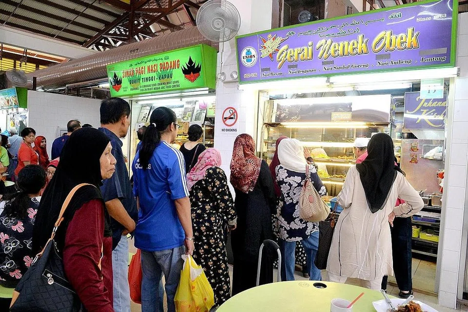 BERATUR PANJANG: Ramai yang kelihatan beratur panjang untuk membeli makanan di gerai Nenek Obek di tingkat dua Pasar Geylang Serai.