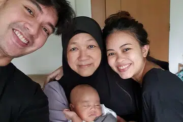 Pasangan Encik Khairil Asyraf Ali (paling kiri) dan Cik Iffa Khalissa Ishak (kanan) mendapatkan bantuan seorang penjaga ibu berpantang, Cik Jamilah Saad, yang menguruskan bayi Khalif Aiden Khairil Asyraf.