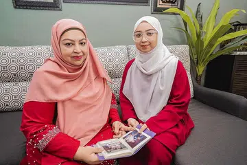 RAI ULANG TAHUN BERSAMA SINGAPURA: Cik Rozita Saeed (kiri), 52 tahun, membuat keputusan di saat akhir untuk melambatkan kelahiran puteri sulungnya hanya untuk Cik Salwa Rozarita, 21 tahun, berkongsi tarikh 9 Ogos bersama Singapura supaya mudah diingati sebagai 'Bayi Hari Kebangsaan'. - Foto BH oleh NUR DIYANA TAHA