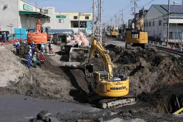 Pekerja penyelamat dan kenderaan berat digunakan dalam kerja menyelamat pemandu trak yang terbenam dalam lubang besar di daerah Yashio pada 1 Februari.