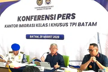Pegawai imigresen Indonesia Encik Ujo Sujoto (tengah), mengadakan sidang media berhubung siasatan dakwaan peras ugut pelancong asing di Batam, di Pejabat Imigresen Batam pada 29 Mac 2026. Pihak berkuasa mengesahkan terdapat petunjuk salah laku melibatkan orang tengah dan seorang pegawai, yang kini telah digantung daripada tugas sementara siasatan lanjut dijalankan.