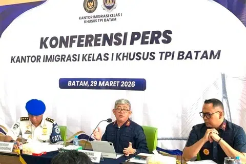 Pegawai imigresen Indonesia Encik Ujo Sujoto (tengah), mengadakan sidang media berhubung siasatan dakwaan peras ugut pelancong asing di Batam, di Pejabat Imigresen Batam pada 29 Mac 2026. Pihak berkuasa mengesahkan terdapat petunjuk salah laku melibatkan orang tengah dan seorang pegawai, yang kini telah digantung daripada tugas sementara siasatan lanjut dijalankan.