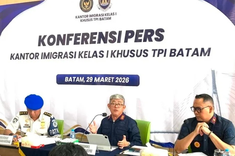 Pegawai imigresen Indonesia Encik Ujo Sujoto (tengah), mengadakan sidang media berhubung siasatan dakwaan peras ugut pelancong asing di Batam, di Pejabat Imigresen Batam pada 29 Mac 2026. Pihak berkuasa mengesahkan terdapat petunjuk salah laku melibatkan orang tengah dan seorang pegawai, yang kini telah digantung daripada tugas sementara siasatan lanjut dijalankan.