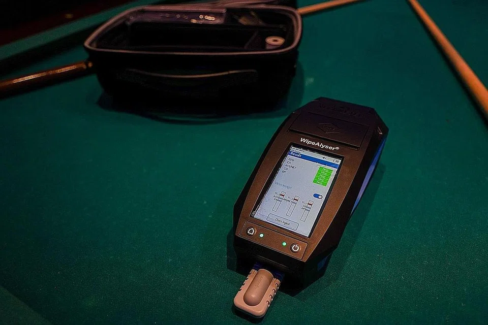 KEPUTUSAN PANTAS: Selain daripada kit ujian air liur, CNB juga menggunakan sebuah peranti elektronik mudah alih yang mempunyai pencetak bersepadu untuk dokumentasi pantas keputusan ujian. - Foto ZAOBAO